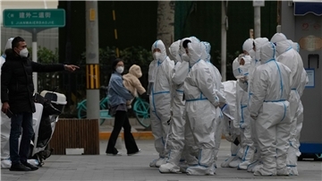 Arbeiter in Schutzkleidung versammeln sich in Peking zu ihrem Dienst. Die Behörden lockerten die Anti-Coronavirus-Bestimmungen in einzelnen Gebieten, bekräftigten aber Chinas strenge „Null-COVID“-Strategie.
