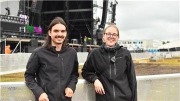 Aaron Münch und Luana Oelze lehnen an einem Zaun auf dem Deichbrand Festival.