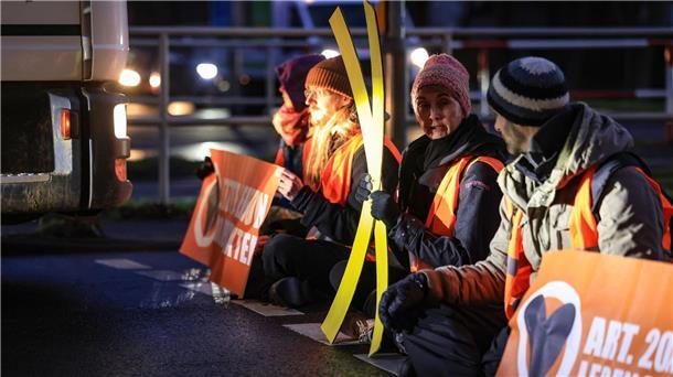 Aktivisten der Gruppierung Letzte Generation blockieren eine Straße in Köln.