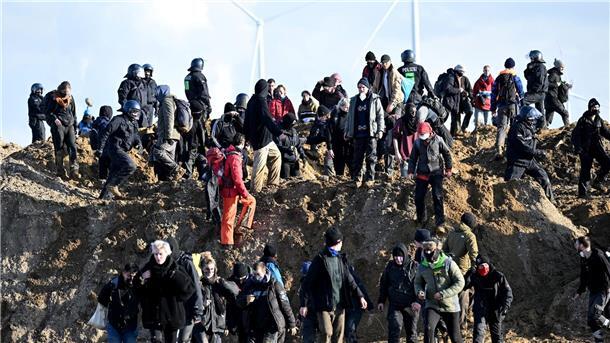 Aktivisten und Kohle-Gegner laufen an der Abbruchkante des Braunkohlentagebaus Garzweiler.