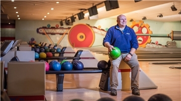 Ein Mann auf einer Bowlingbahn.