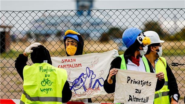 Als Pinguine verkleidete Aktivistin versuchen den Flughafen auf Sylt zu blockieren.