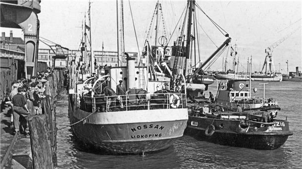 Schwarz-Weiß-Aufnahme: Drei Schiffe liegen hintereinander an einer Pier im Hafen von Cuxhaven.