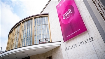 Am Gebäude des Schillertheaters hängt ein Banner der Komischen Oper Berlin.
