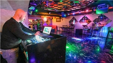 Ein Mann steht in einem leeren Club an einem DJ-Pult. Am Leher Bahnhof gibt es seit einigen Monaten den Club „Infinity“.