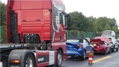 Fahrzeuge stehen nach einem Unfall beschädigt auf eine Autobahn.