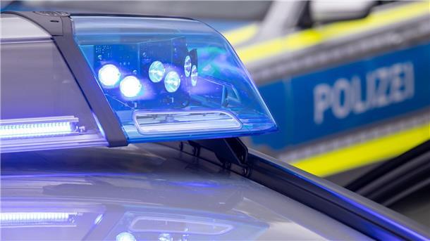 Bild von einem Blaulicht und einem Polizeiwagen im Hintergrund