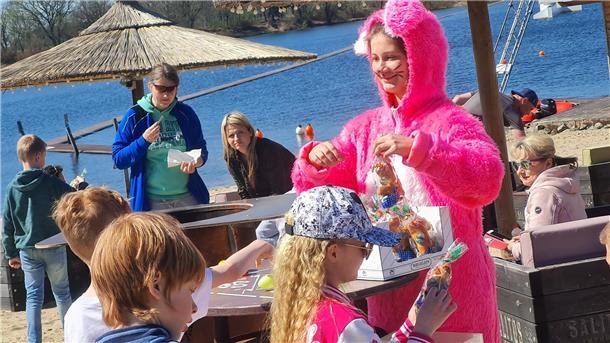 Kinder und eine Frau in einem pinken Hasenkostüm