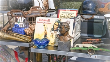 Verschiedene Waren stehen auf einem Flohmarkttisch und werden zum Verkauf angeboten. Der Flomaxx-Flohmarkt lockt viele Besucher auf den Ikea-Parkplatz am Bohmsiel.
