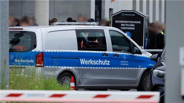 Zwei Tote nach Schüssen in Mercedes-Werk Am Tor 5 zum Werksgelände steht ein Fahrzeug mit der Aufschrift „Werkschutz“.
