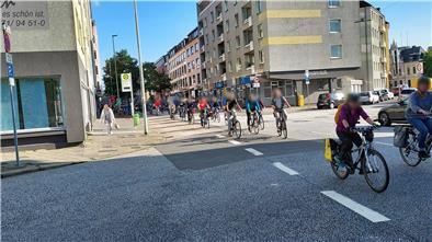 Fahrradfahrer überqueren eine Straße.