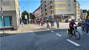 Fahrradfahrer überqueren eine Straße.