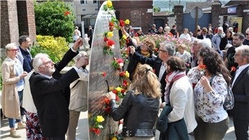 An dem Mahnmal für den ermordeten Pfarrer Jacques Hamel steckten Hunderte von Menschen am 8. Mai in St.-Etienne-du Rouvray Rosen in die Metallscheibe.