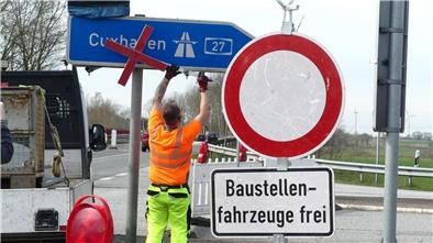 An der Anschlussstelle Uthlede entfernen Bauarbeiter die Verkehrszeichen, die auf die Sperrung der A27 hinweisen.