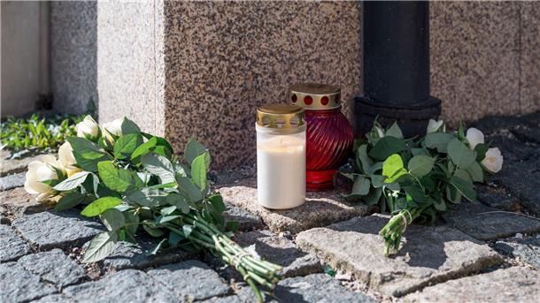 Polizei: Nichts Neues zu Ermittlungen im Fall Wunsiedel An der Straßenecke zur Zufahrt zum Kinder- und Jugendhilfezentrum, in dem eine Zehnjährige tot aufgefunden wurde, liegen weiße Rosen und Grablichter auf dem Gehweg.