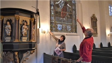 An dieser Stelle ist der Übergang von alter zu angebauter Kirche zu sehen. Berit und Hartmuth Seitz weisen aufs Mauerwerk des Gotteshauses hin, das unter Regie von Pastor Heinrich Rüther dereinst um 5,50 Meter erweitert wurde.