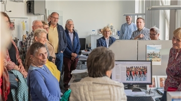 Viele Menschen stehen in einem Büro.