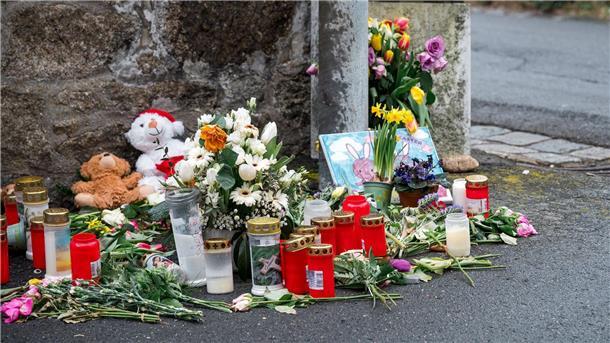 An einer Mauer vor dem Kinder- und Jugendheim in Wunsiedel, in dem eine Zehnjährige tot aufgefunden wurde, liegen Blumen, Kerzen und Stofftiere.