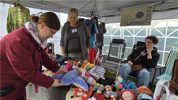 Drei Frauen an einem Stand mit Strickwaren auf dem Grünen Markt in Seefeld