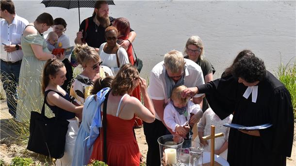 Kind wird am Fluss getauft