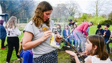 Frau auf Wiese mit Kindern