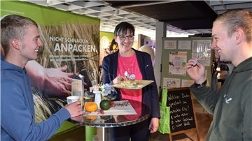 Andrea Vogt vom Kreislandvolkverband mit zwei jungen Besuchern am Stand des Landvolks.