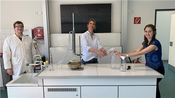 „Dann destillieren wir jetzt selbst“ Angewandte Chemie für die Lehrkräfte Dr. Kim Heymann, Dr. Carolin Krumme und Kristin Stuhr (v.l.) beim Abfüllen der Desinfektionsflüssigkeit.