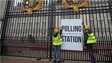 Anhänger der Kampagnengruppe Republic hängen ein Wahllokalschild ans Geländer des Buckingham Palace in London.