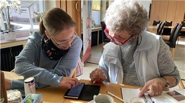 Anja Hülsebusch (links) zeigt Inge Höpken wie man einen Termin im Kalender des Smartphones anlegt.