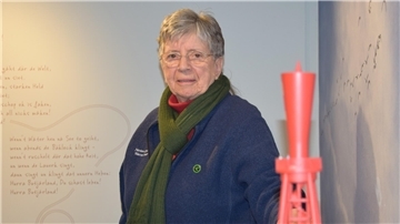 Annegret Martens steht vor einem Leuchtfeuer-Modell im Nationalparkhaus Museum Fedderwardersiel. 