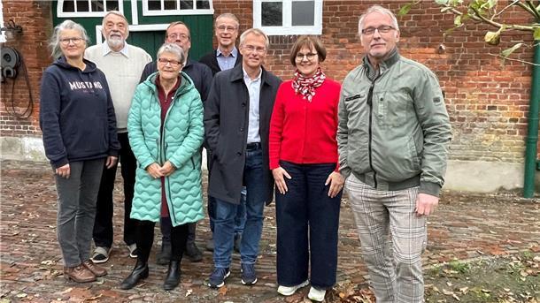 Gruppe von Menschen vor einem Bauernhof