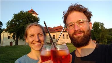 Frau und Mann stoßen mit Cocktails an.