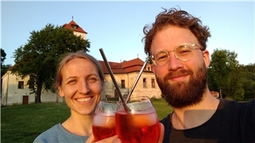Frau und Mann stoßen mit Cocktails an.