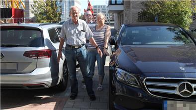 Anwohner Bärbel und Dieter Weber sowie Wolfgang Freers zeigen, wie der Mercedes die Freifläche zuparkt. 