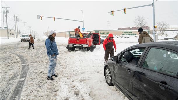 Anwohner helfen einem im Schnee steckengebliebenen Autofahrer in Buffalo.