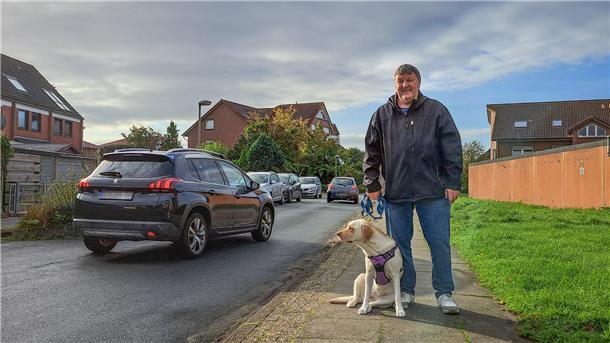 Bild von Helmut Bittner und seiner Labradorhündin in der Bonner Straße, durch die gerade zwei Autos fahren