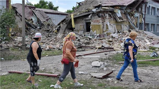 Krieg gegen die Ukraine: So ist die Lage Anwohnerinnen gehen in Komyschuwacha an einem Gymnasium vorbei, das von russischem Beschuss schwer beschädigt wurde.