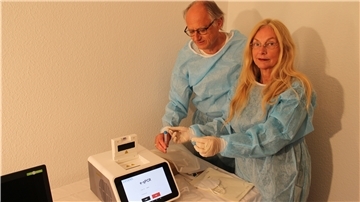 Apotheker Dr. Andreas Völsch und seine Frau Bärbel zeigen für unser Foto, wie das neue PCR-Testgerät funktioniert.