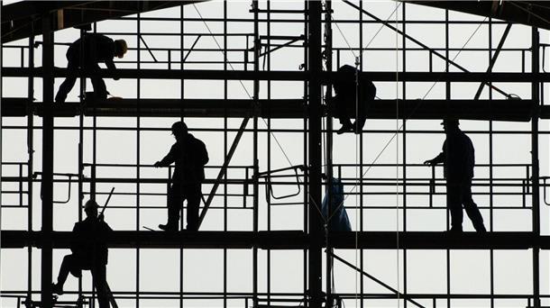 Ifo-Beschäftigungsbarometer sinkt Arbeiter montieren auf einem Gerüst die Glasfassade des Bahnhofs von Frankfurt am Main.