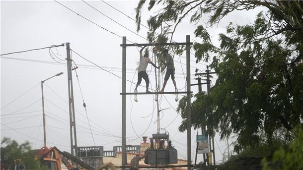 Arbeiter reparieren in Indien einen Transformator, um die Stromversorgung wiederherzustellen.