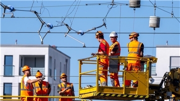 Arbeiter reparieren in München eine abgerissene Oberleitung.