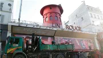 Arbeiter sichern den Bereich vor dem Kabarett, nachdem die Flügel des Windrads des „Moulin Rouge“ in der Nacht abgestürzt sind.