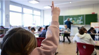 Wie die Schüler des Nordenhamer Gymnasiums lernen, Fake News zu erkennen Ein Mädchen hebt im Unterricht in einer Schule den Finger.