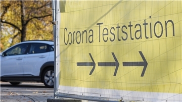 Gelbes Schild mit dem Hinweis Corona-Teststation.