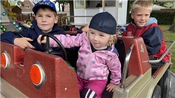 Kinder sitzen in einem Karussell. Beim Sommerfest des SV Horstedt wird auch ein Kinderkarussell seine Runden drehen.
