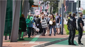Eine Frau in einer Demo trägt ein Schild mit „Omas gegen Rechts“ .