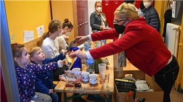 Eine Helferin bei der Tafel Bremerhaven betreut eine geflüchtete, neu angekommene Familie aus der Ukraine