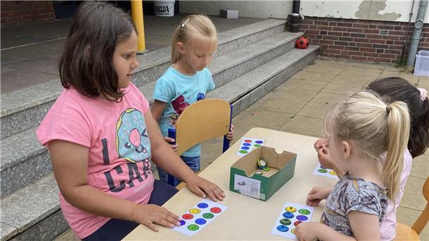 So geht Nachhaltigkeit: Grundschüler basteln aus Müll Brettspiele Kinder spielen ein Spiel