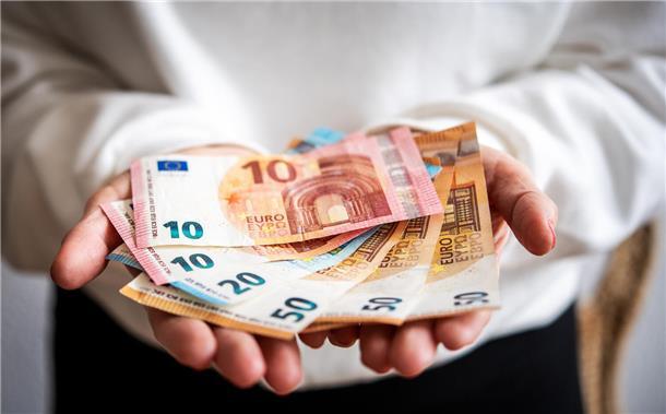 Ein Mann hält Geldscheine in der Hand