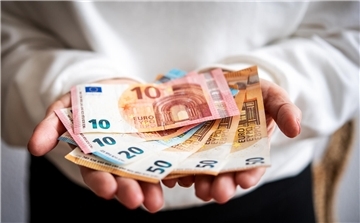 Ein Mann hält Geldscheine in der Hand